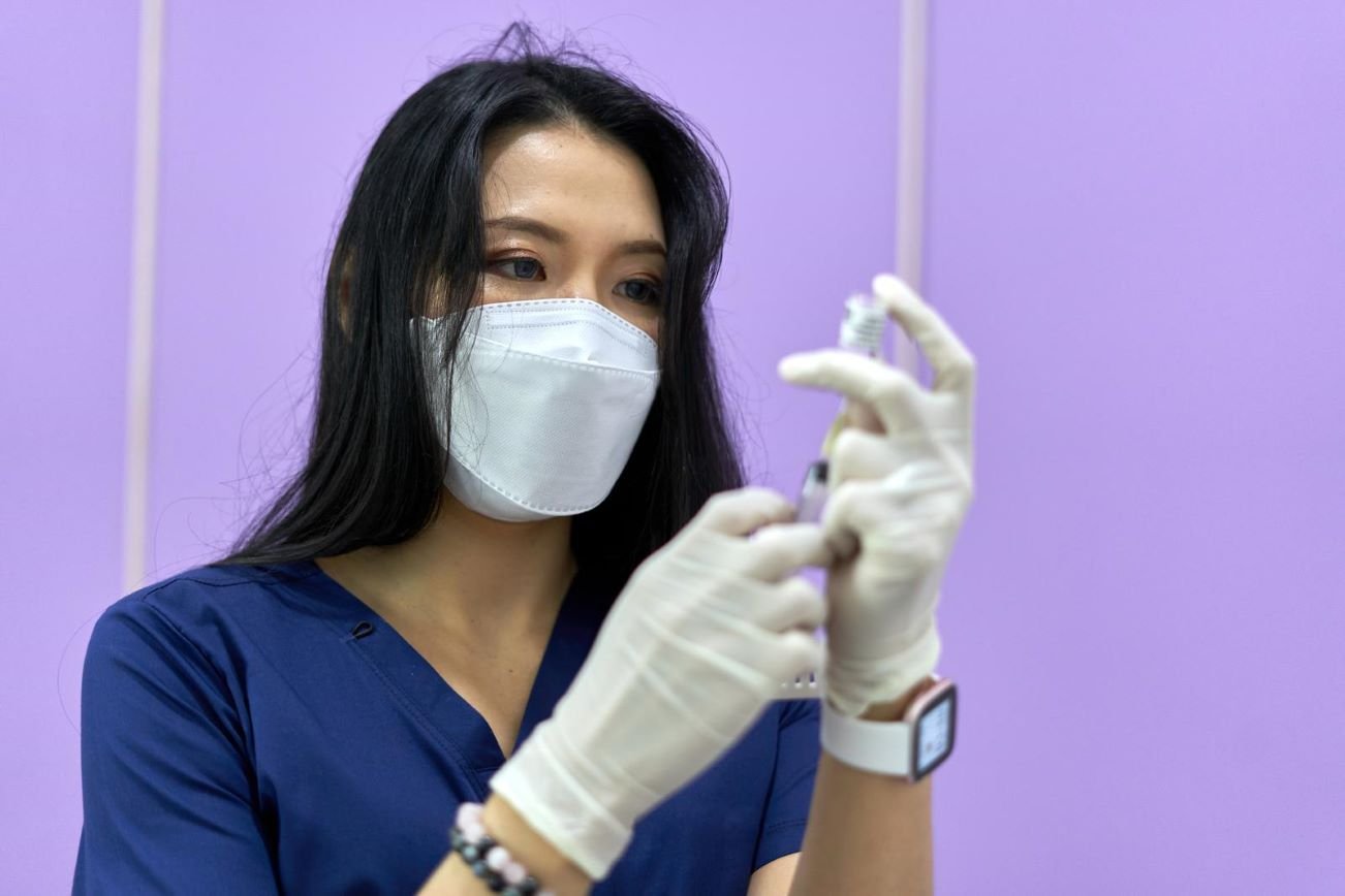 Female healthcare professional preparing syringe for Botox filler training