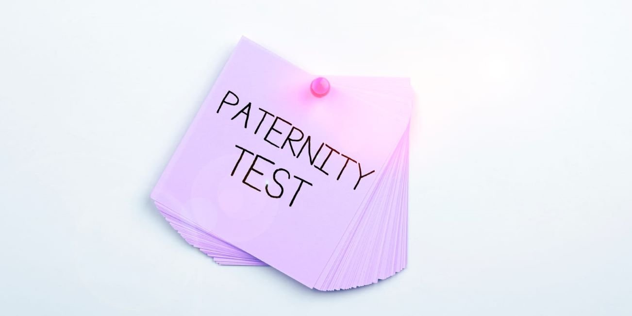 Stack of purple notes pinned with the words 'Paternity Test' written on top