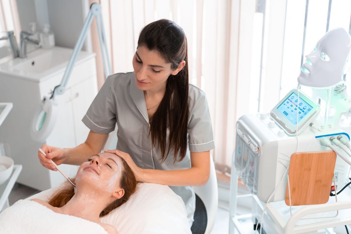 Esthetician applying a soothing mask during a facial treatment, preparing the skin for a Morpheus8 procedure